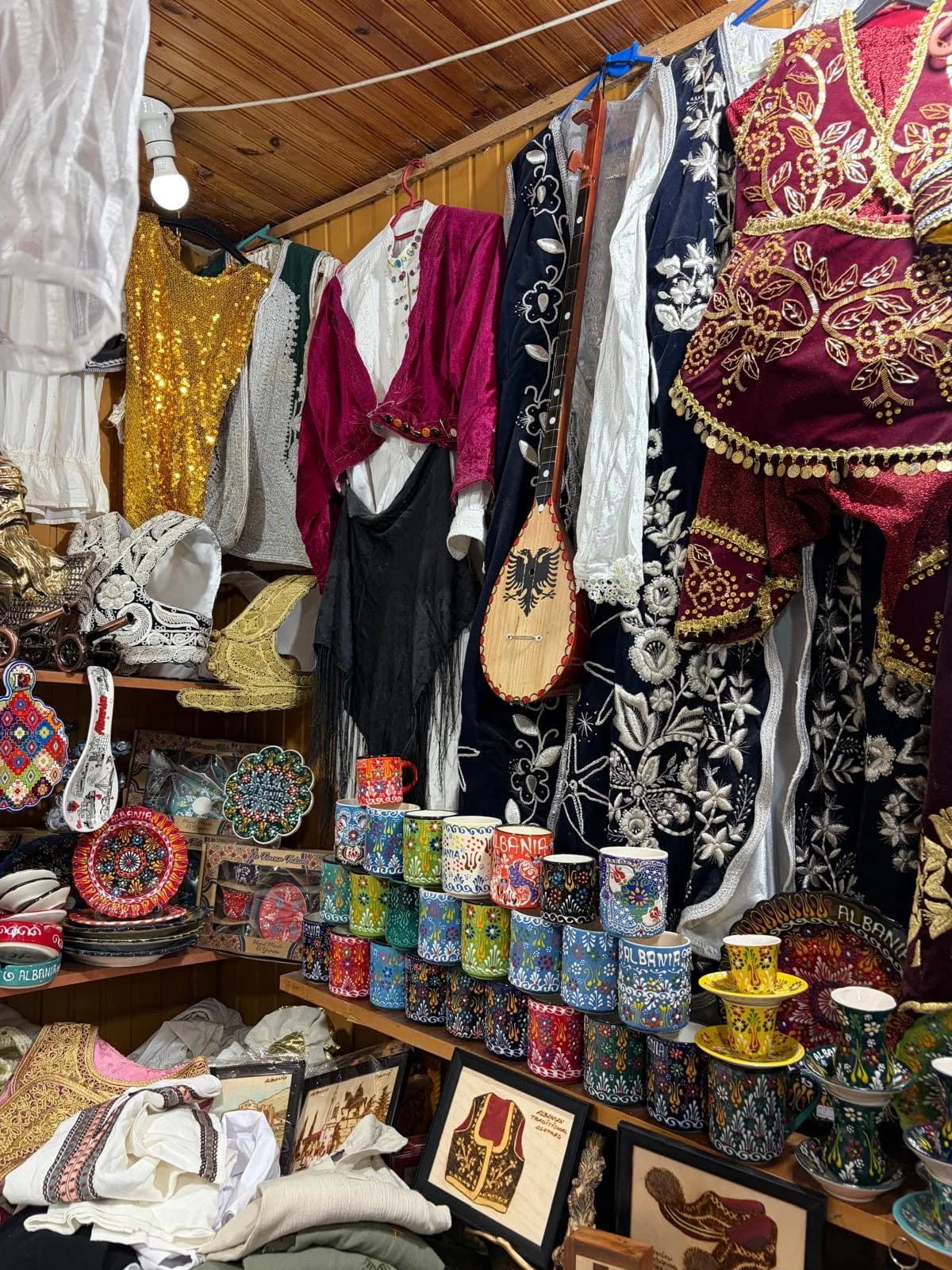 Embroidered clothing and painted ceramics at a bazaar stall