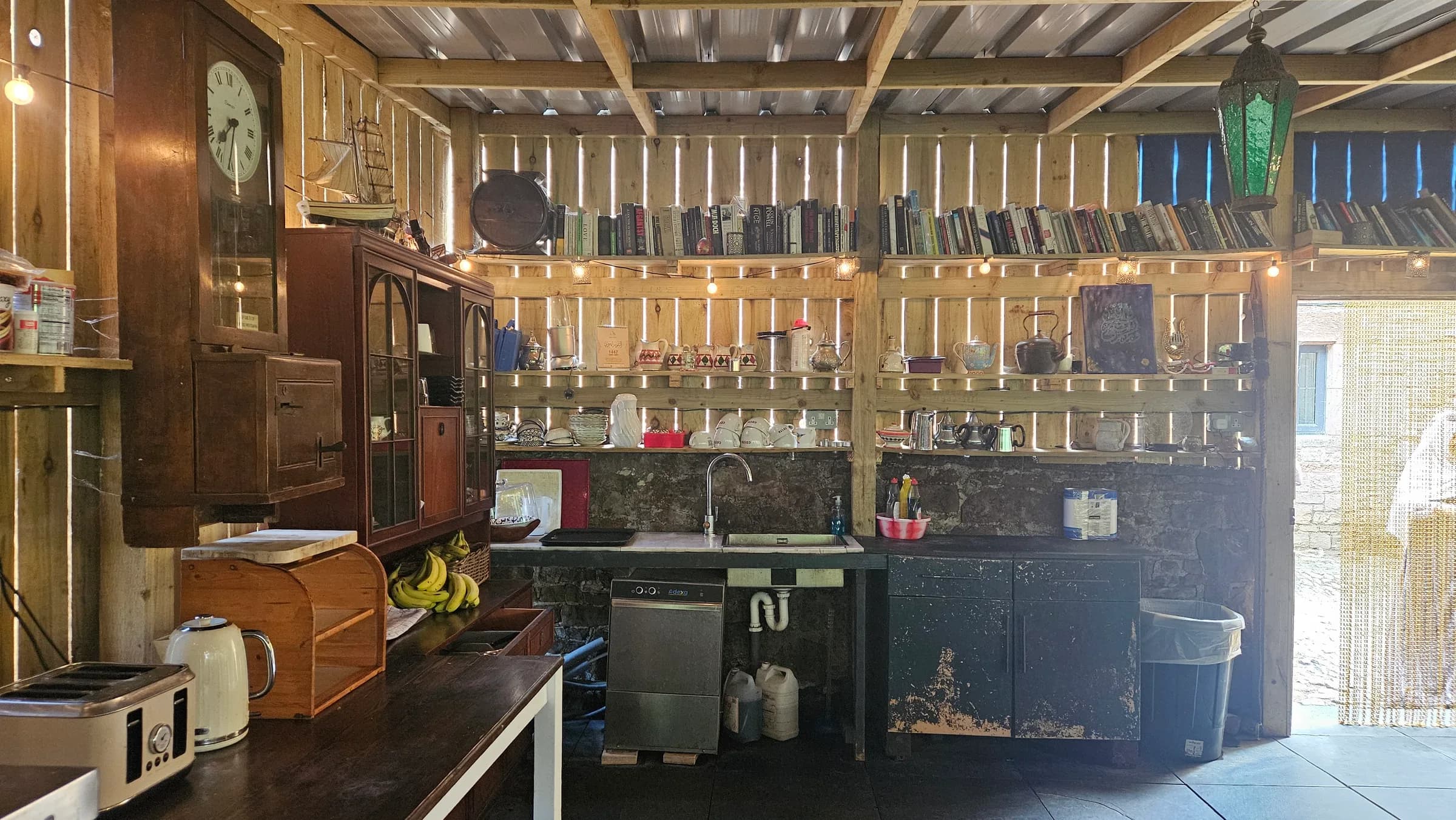 The rustic shared kitchen with shelves of books