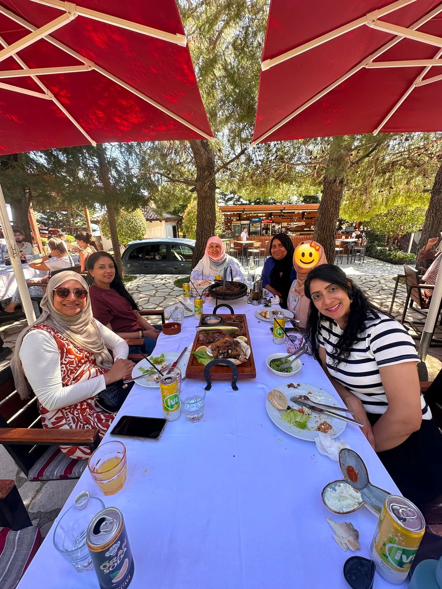 Sisters sharing a meal at a long outdoor table