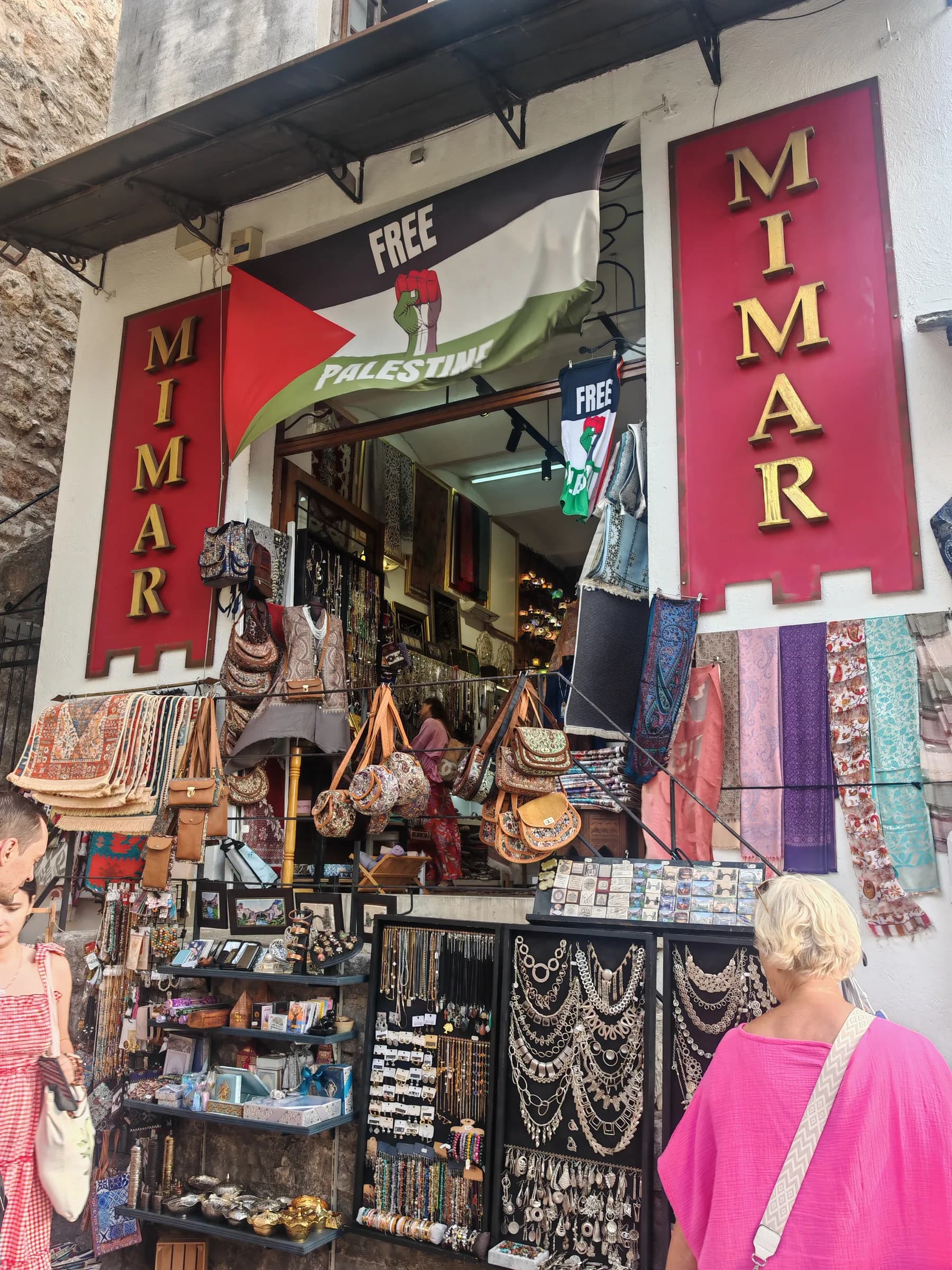 A shop in Mostar's Old Bazaar with rugs, bags and a Free Palestine flag