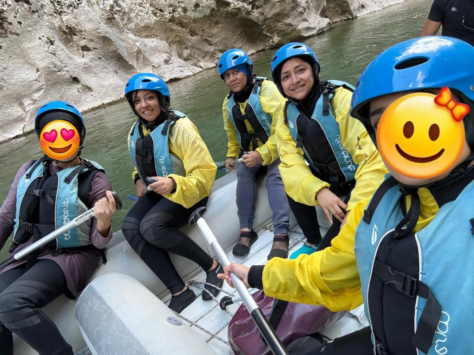 Sisters in helmets and life jackets white-water rafting in Konjic
