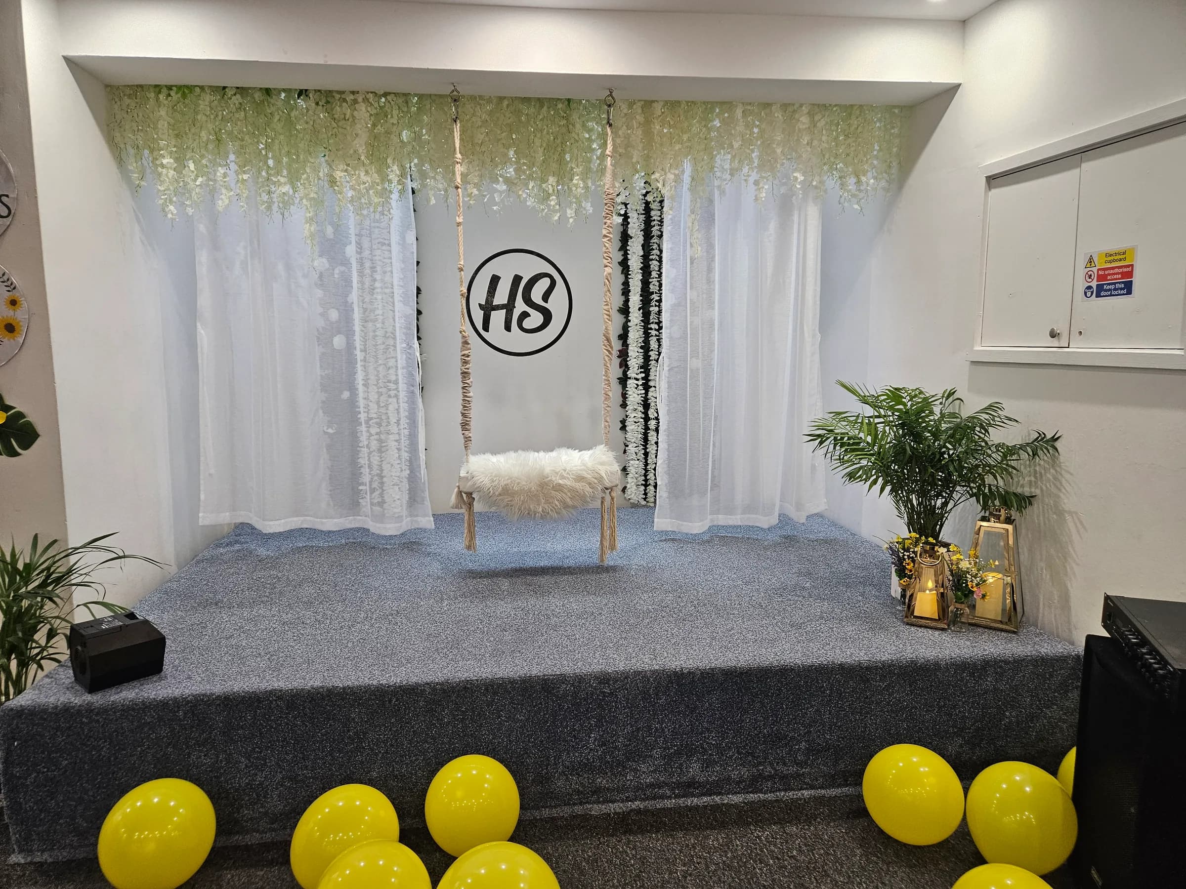The festival stage with a swing seat, flowers and yellow balloons