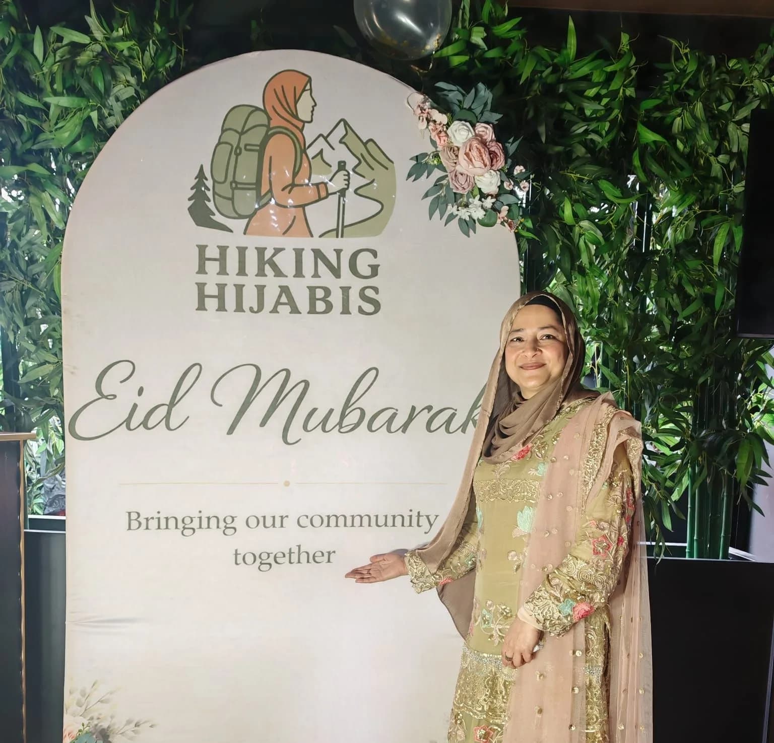 Our founder by the Eid Mubarak board reading: bringing our community together