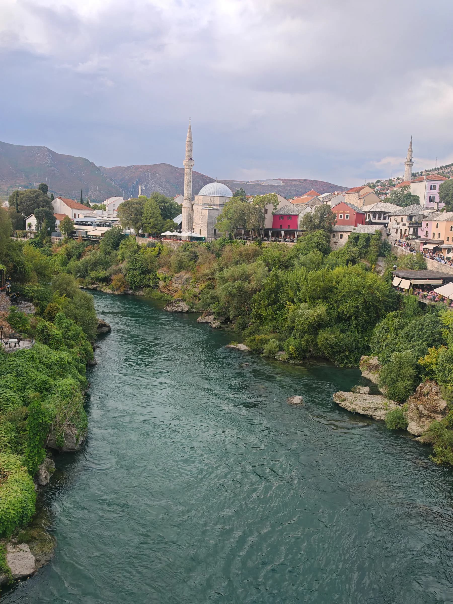 The Neretva river running through Mostar, with a mosque minaret above the old town